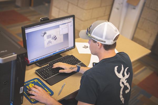 An information technology student creating a 3D model at a computer